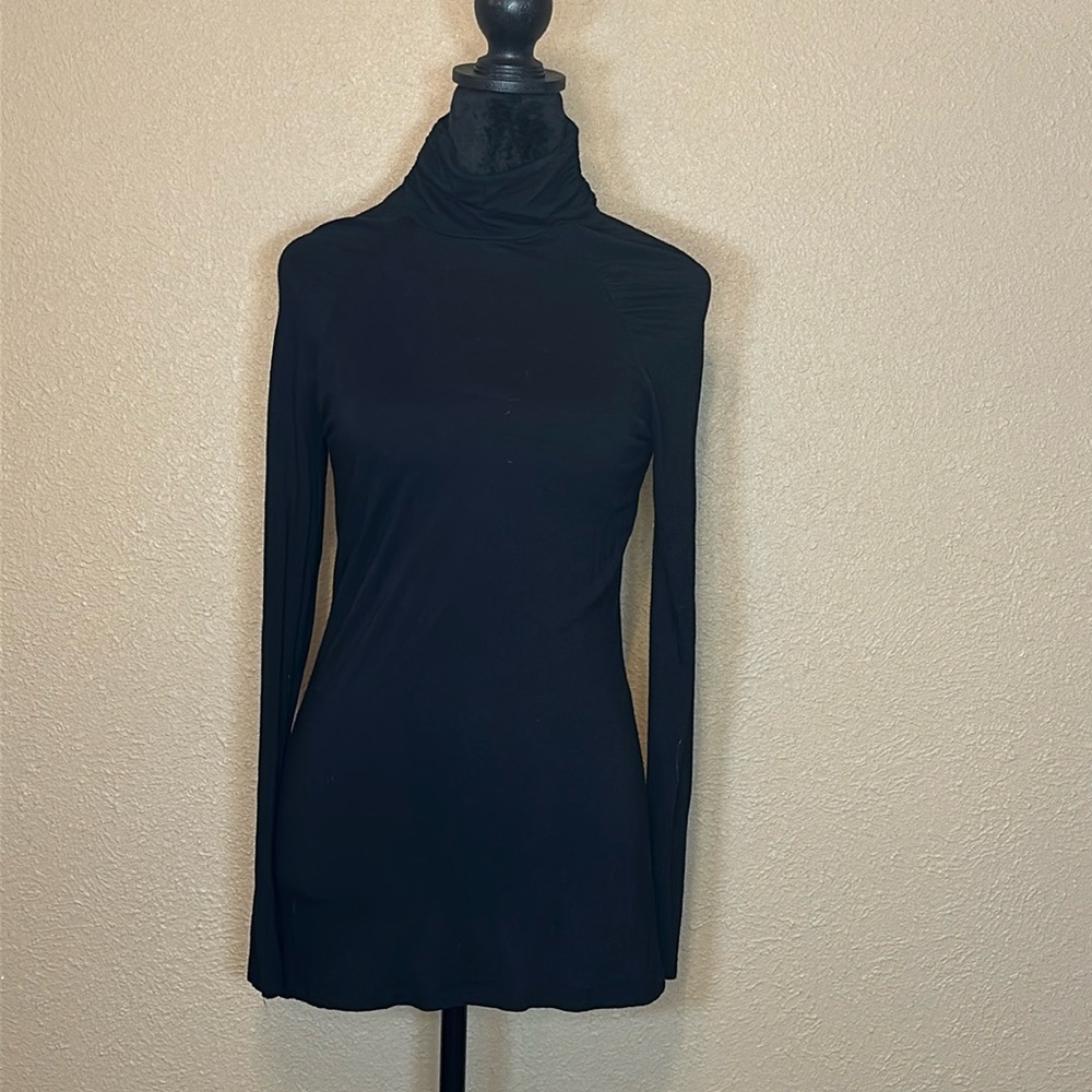 Black turtleneck with long sleeves. Ruched at shoulders